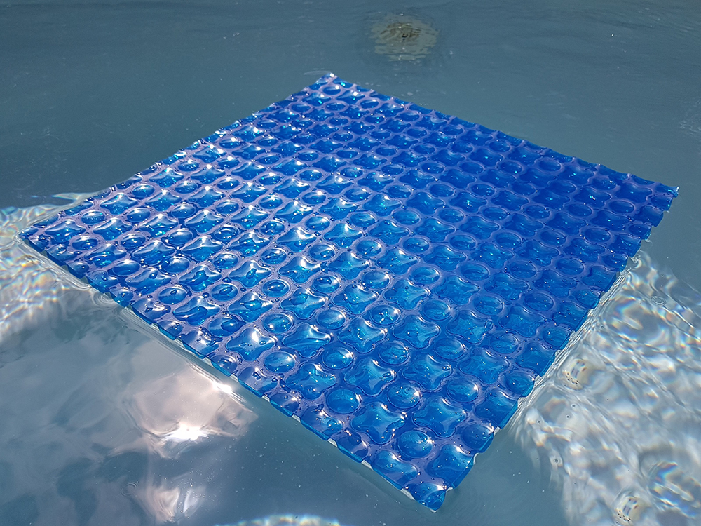 Muestra manta térmica OXO Optimal Blue flotando en piscina